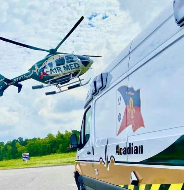 101729665_10214091790447807_8851769683993427968_n A flight paramedic stands on top of a building next to an Acadian Air Med helicopter.
